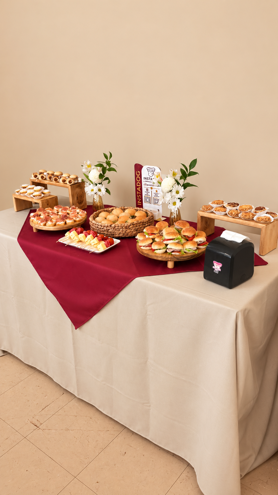 Mesa de brunch con mini sándwiches, brochetas de fruta y flores